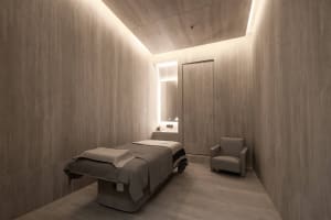 Modern spa treatment room with granite walls and floor.