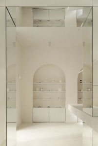 Minimalist, modern interior space with concrete shelving and arched recesses.