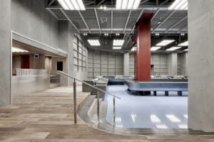 Modern industrial-style swimming pool facility with concrete materials and spacious design