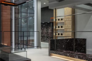 Modern, luxurious fitting room interior with glass, marble, and concrete materials.