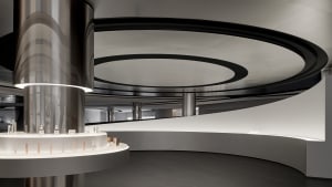 A modern retail storefront featuring a curved glass facade and metal elements.
