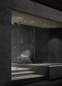 Concrete and glass installation art with lighting accents.