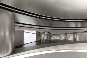 A sleek, modern museum exhibit space featuring glass walls and a circular ceiling.