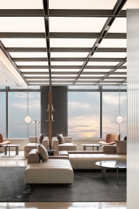 Modern industrial-style lobby with metallic ceiling, glass windows, and leather seating.