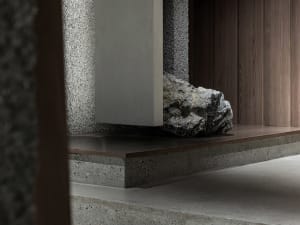 A modern industrial interior design featuring concrete and rock elements on the ground