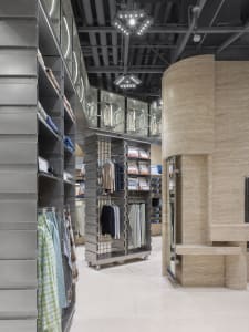 A modern retail interior featuring metallic clothing racks and shelves.