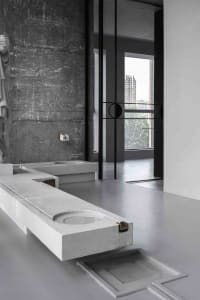 Minimalist bathroom with concrete sink and wall, industrial-style decor.