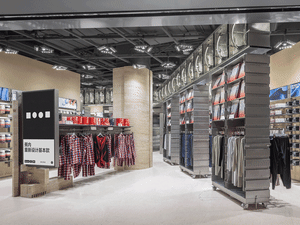 Modern retail store interior with metal clothing hangers and clothing.