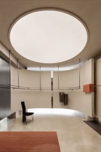 Modern clothing retail store with metallic clothing rack and minimalist design.