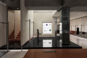 Modern minimalist retail space featuring polished concrete surfaces, glass showcases, and minimalist decor.