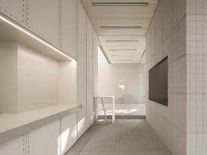 A minimalist office interior with concrete flooring and glass walls.