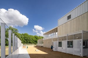 Concrete industrial-style dog kennel building with a person and dog