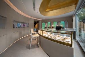 A modern jewelry shop featuring sleek metal displays, glass showcases, and mirrored backgrounds.