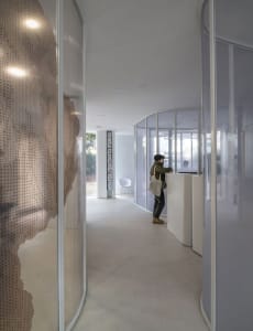 A modern reception area with a glass curtain and a white reception desk.