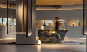 A sleek, modern museum display featuring granite and illuminated vases.