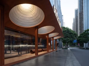 A sleek, modern storefront with metallic texture roofing and large glass windows.