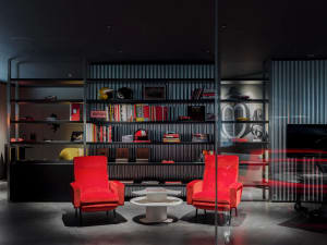 Modern office interior with metal shelves, wooden chairs, and glass partitions.