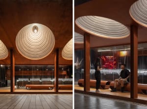 A modern restaurant interior featuring metallic elements and a unique ceiling design.