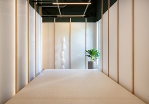 A minimalist office space featuring a paper lantern sculpture and a potted plant.
