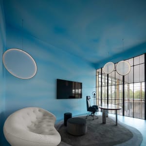 A modern office space featuring glass walls with minimalist interior design.