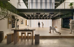 A modern commercial interior fitness studio featuring wooden floors, white walls, and a minimalist design.