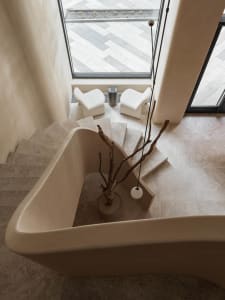 Modern marble bathroom with natural wood accents and white ceramic tub, featuring a minimalist aesthetic and clean lines.