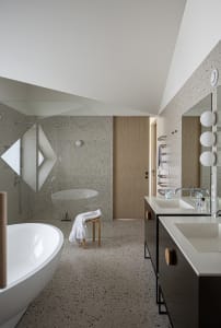 Modern bathroom featuring white tiled walls and floor, a freestanding bathtub, a walk-in shower with a glass door, and a doub