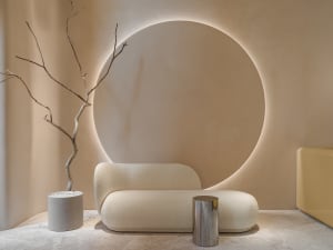 A modern living room with textured fabric furniture, concrete floor, and metal accents.