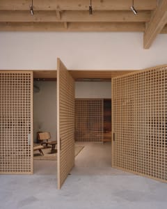 Open wooden lattice doors leading into a minimalist interior design space.