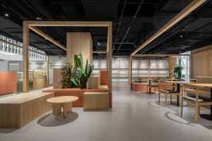 An elegant, minimalist cafe interior with warm wood elements and green plants, featuring comfortable seating arrangements and