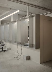 A modern hair salon interior with concrete walls and minimalist design.