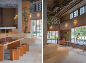An industrial-style coffee shop interior with concrete walls, seating areas, and natural light.