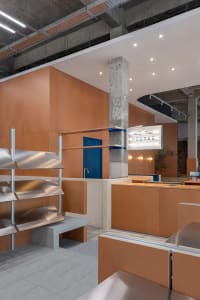 A contemporary food court featuring a modern industrial design with metal, wood, and concrete materials.
