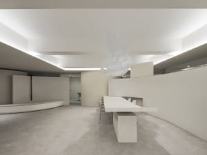 A minimalist office space featuring concrete walls and floors.