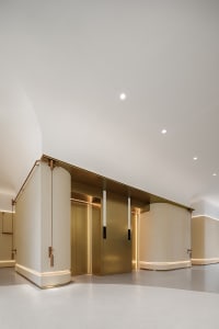 A modern minimalist lobby with a gold finish and sleek design.