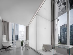 Modern office interior featuring concrete walls and white furniture.