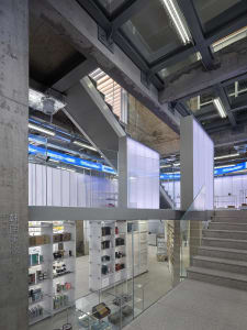 A modern retail storefront with concrete walls, glass displays, and metal accents.