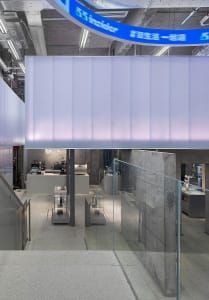 Modern, minimalist coffee shop featuring glass walls and concrete elements.