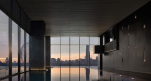 An elegant indoor minimalist swimming pool with glass walls.