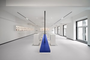 An empty minimalist retail store interior featuring white furniture and base.