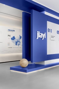 Modern office interior with blue walls, concrete floor, and geometric design elements.