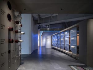 Modern exhibit hall with plastic shelves displaying various products.