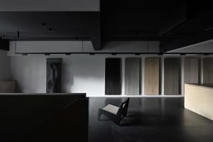A minimalist interior space featuring wood panels and a modern chair on a polished floor.