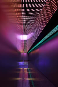 Metal grid corridor illuminated by colorful lights