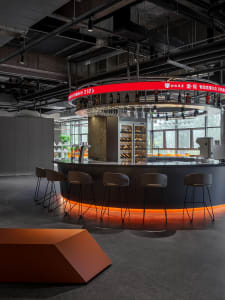 Industrial-style restaurant bar with concrete counter and glass shelves.