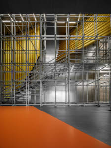 A modern office space featuring metal scaffolding frameworks.