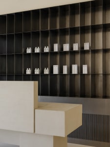 A minimalist interior design featuring metallic, concrete, and glass elements.