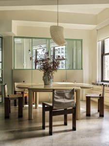 Modern dining room with an integrated glass window and wooden furniture.