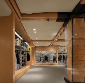 A modern retail store with wooden walls, stone accents, and minimalist design