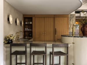 A modern kitchen with wooden cabinets and a marble countertop.